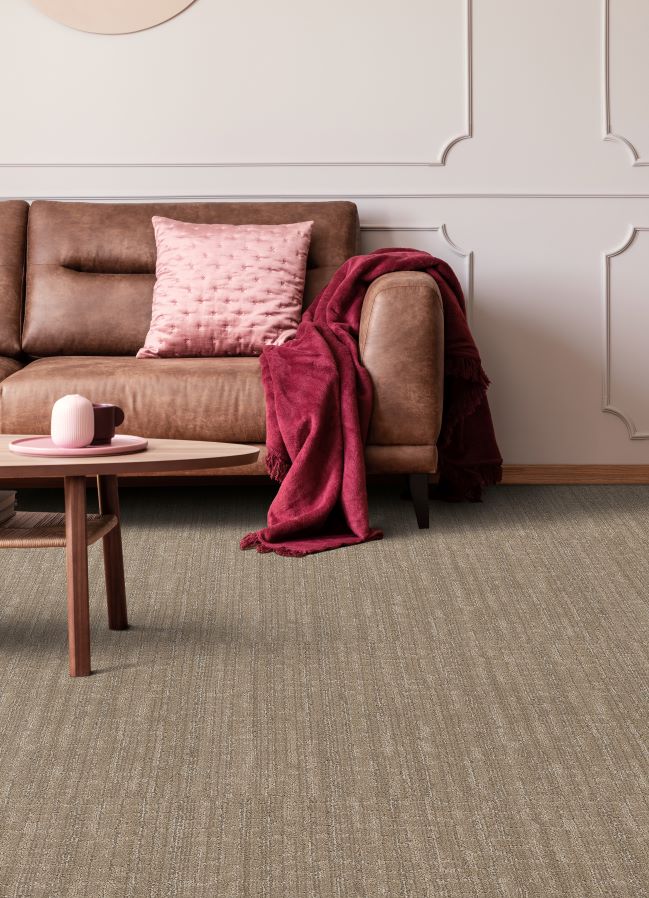 brown textured carpet in a stylish living room with a brown leather couch and pink accents